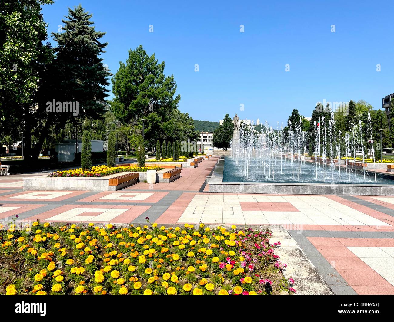 Bulgarian town city centre with decorative public fountains and flowerbeds on a sunny day - Smartphone Captured Stock Image