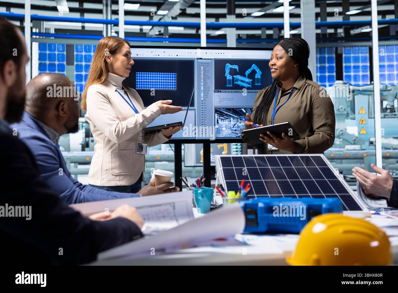 Engineers and scientists collaborate on solar panel research and development, analyzing data and experimenting with advanced materials to develop innovative renewable energy solutions Stock Photo