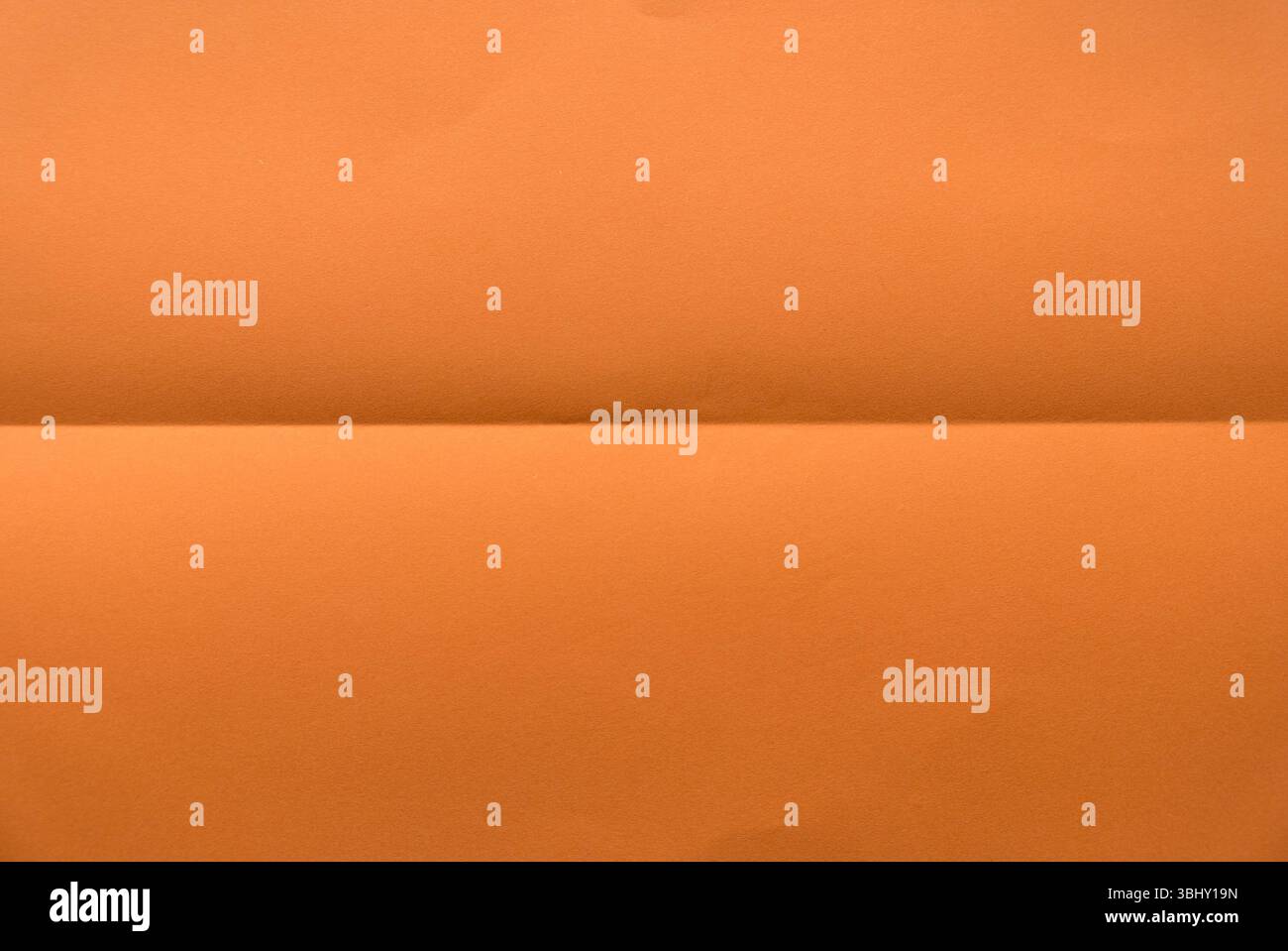 Folded orange color paper for background. Stock Photo