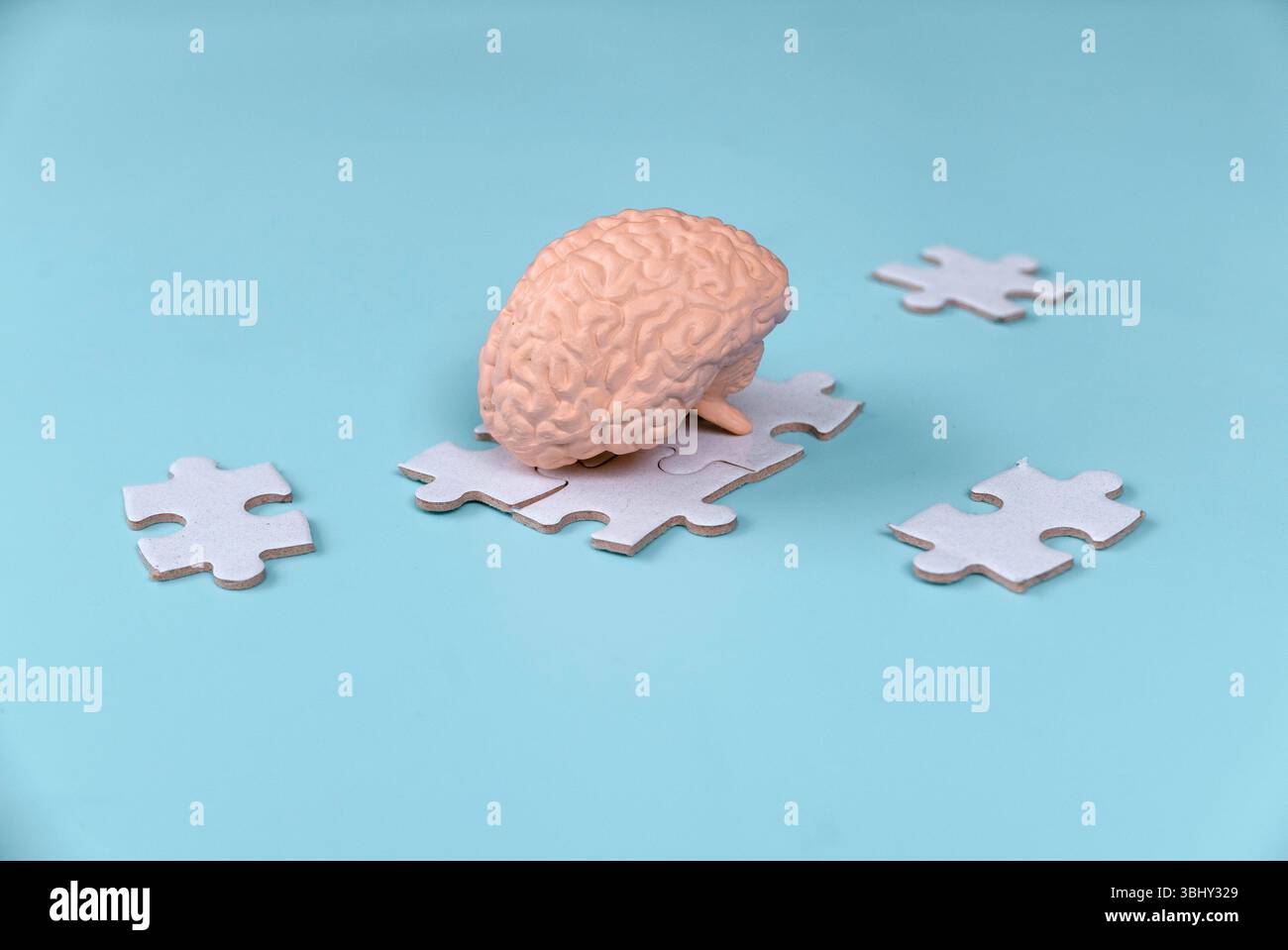 Human Brain Model on Scattered Jigsaw Puzzle Pieces Stock Photo