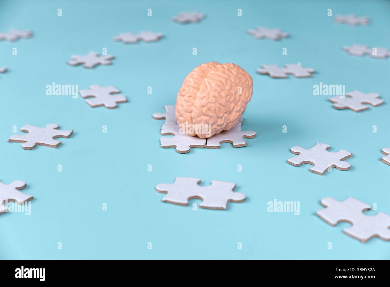 Human Brain Model on Scattered Jigsaw Puzzle Pieces Stock Photo