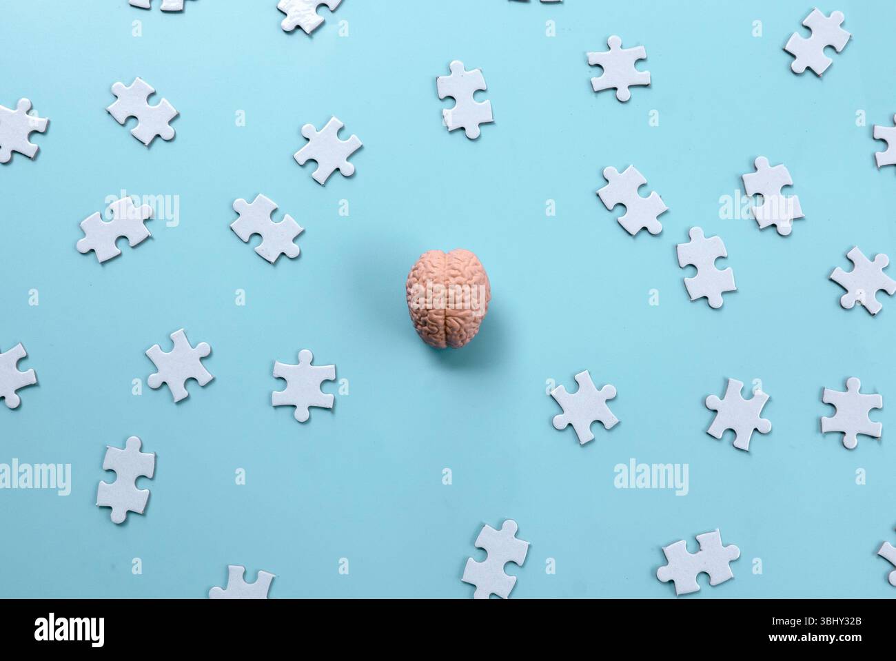 Human Brain Model on Scattered Jigsaw Puzzle Pieces Stock Photo