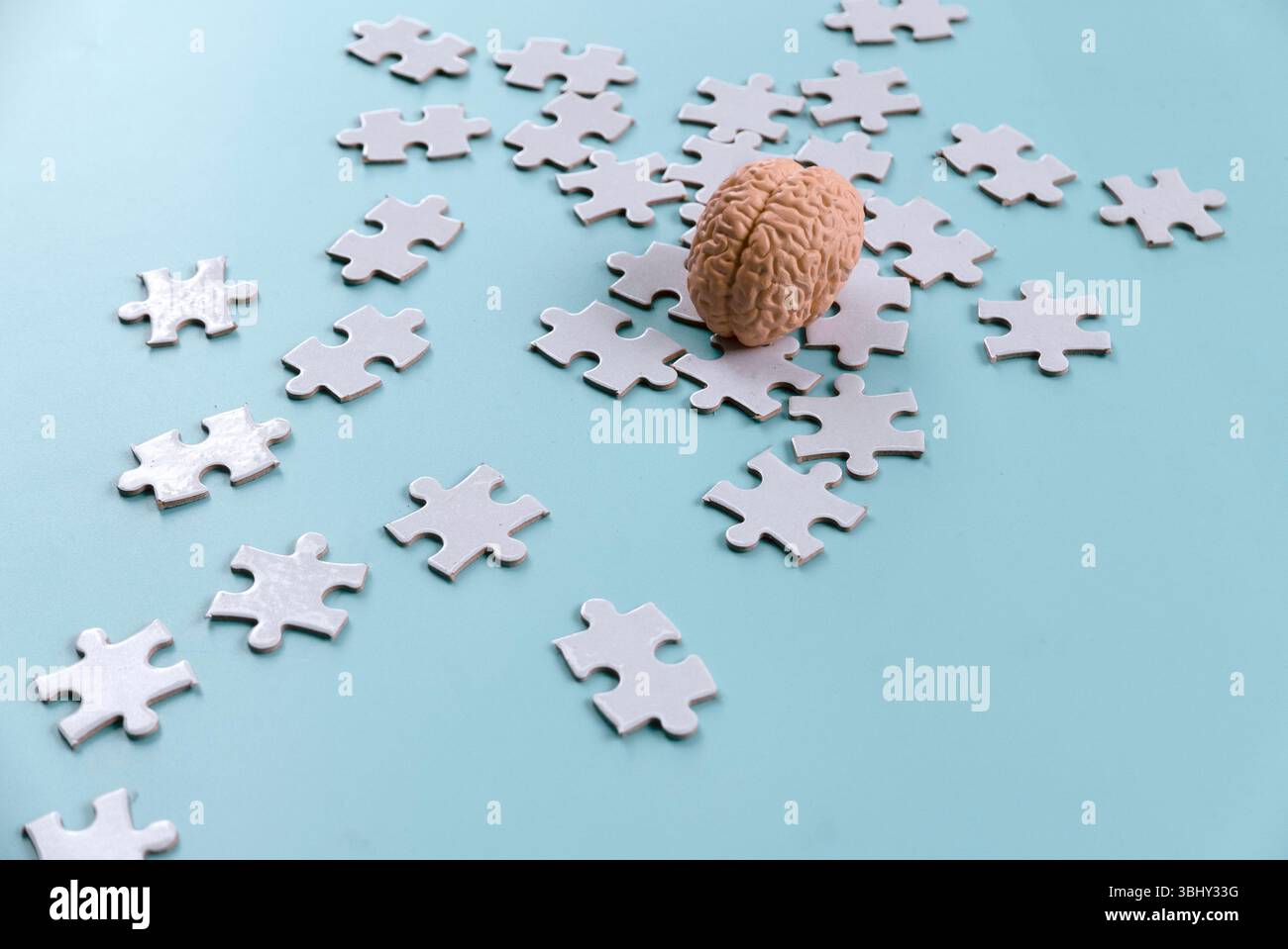 Human Brain Model on Scattered Jigsaw Puzzle Pieces Stock Photo