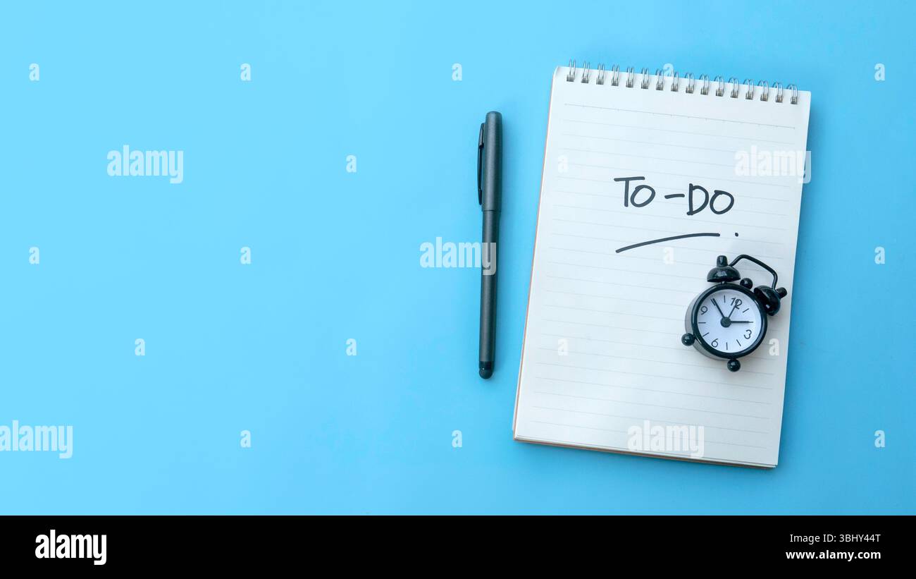 To-Do List with Pen and Alarm Clock on Blue Background Stock Photo