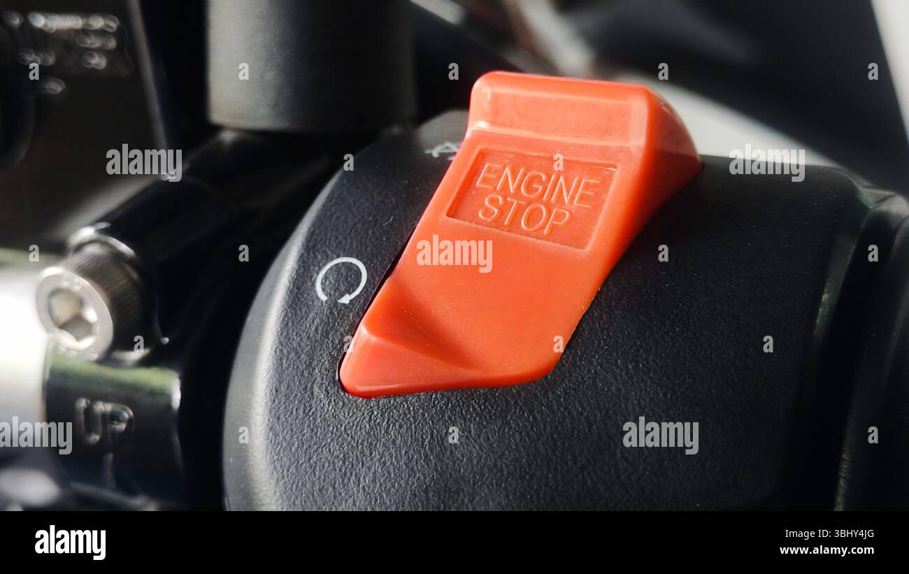 Red Engine Stop Switch on Black Surface with Rotational Arrow Symbol. Stock Photo