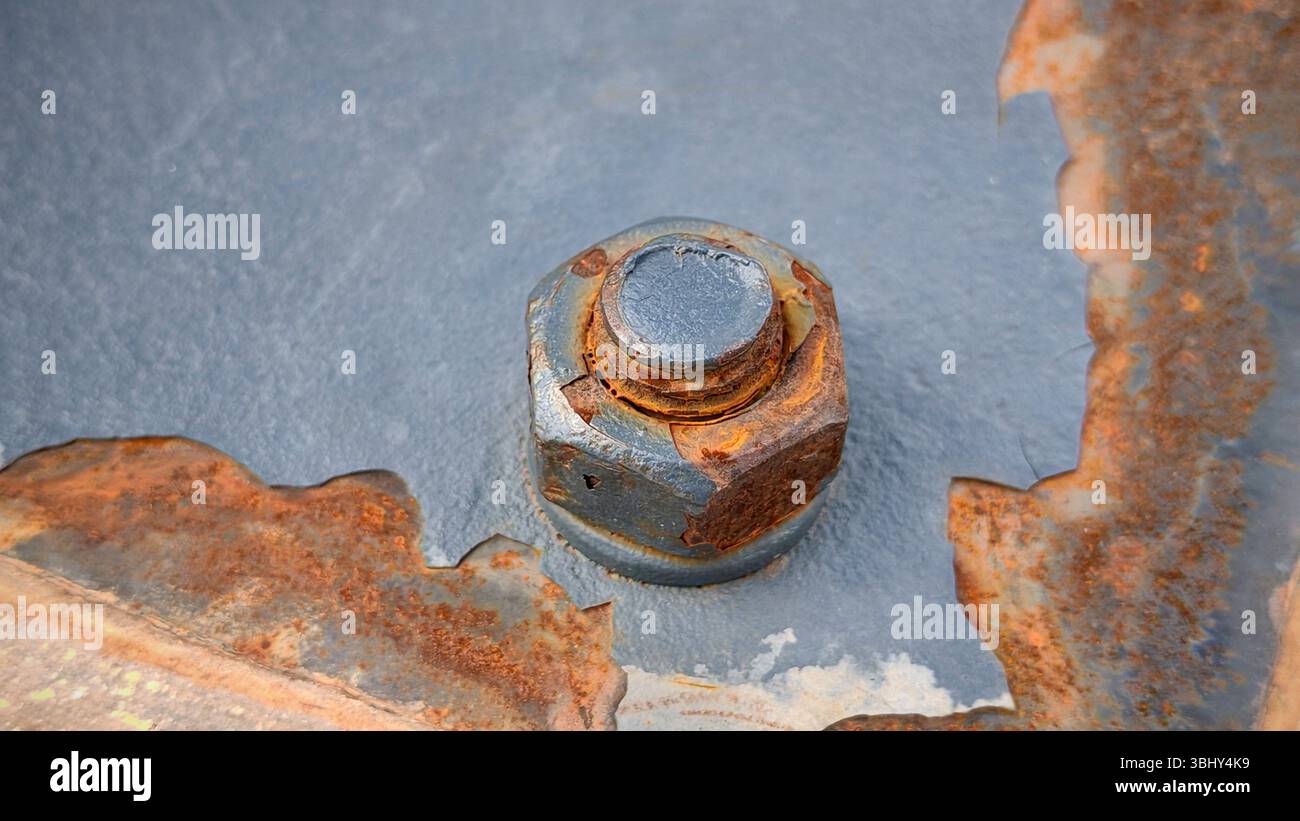 Close-Up View of a Rusty Bolt and Nut on Painted Metal Surface Stock Photo