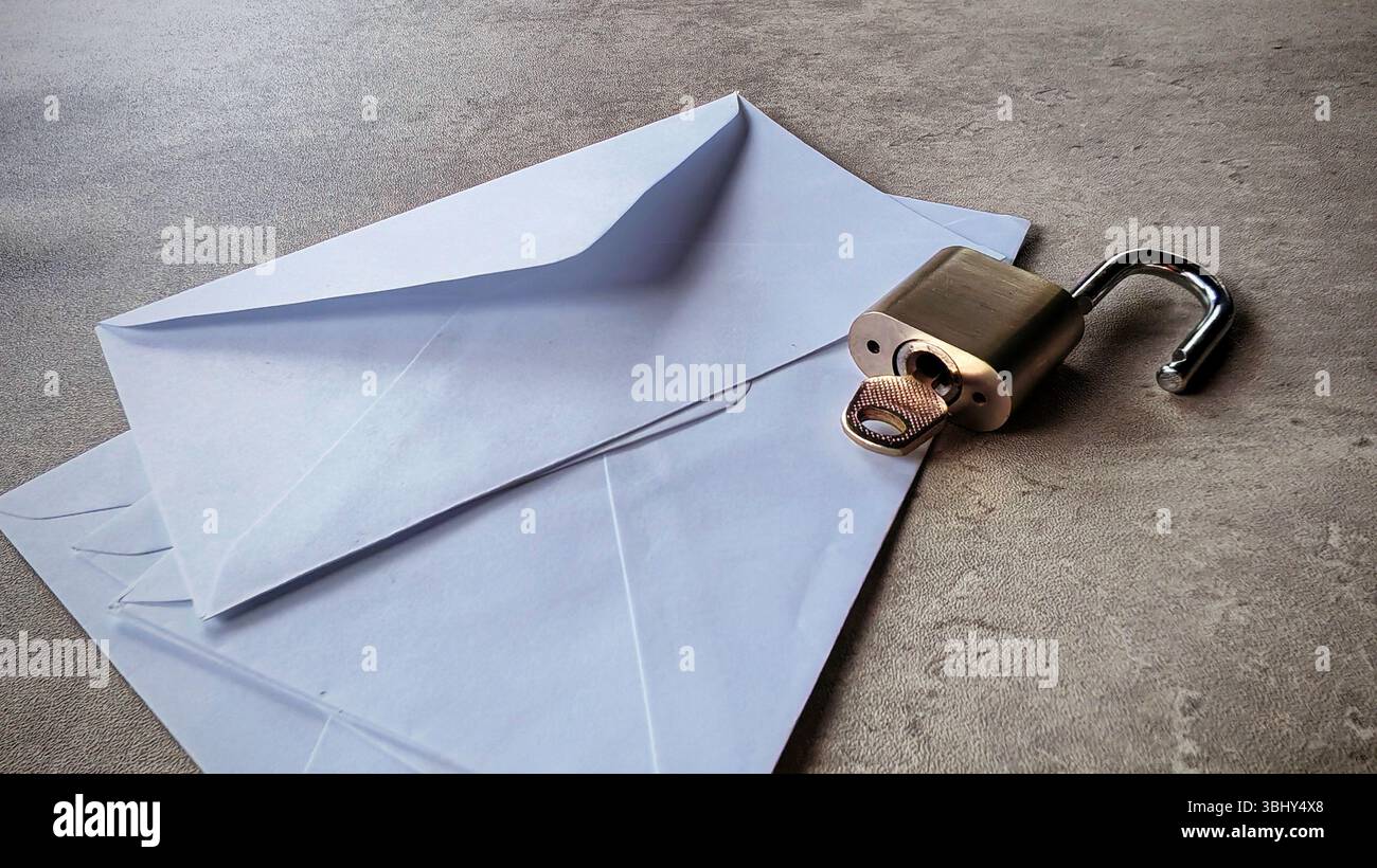 An open envelope and open metallic padlock. Email security concept. Stock Photo