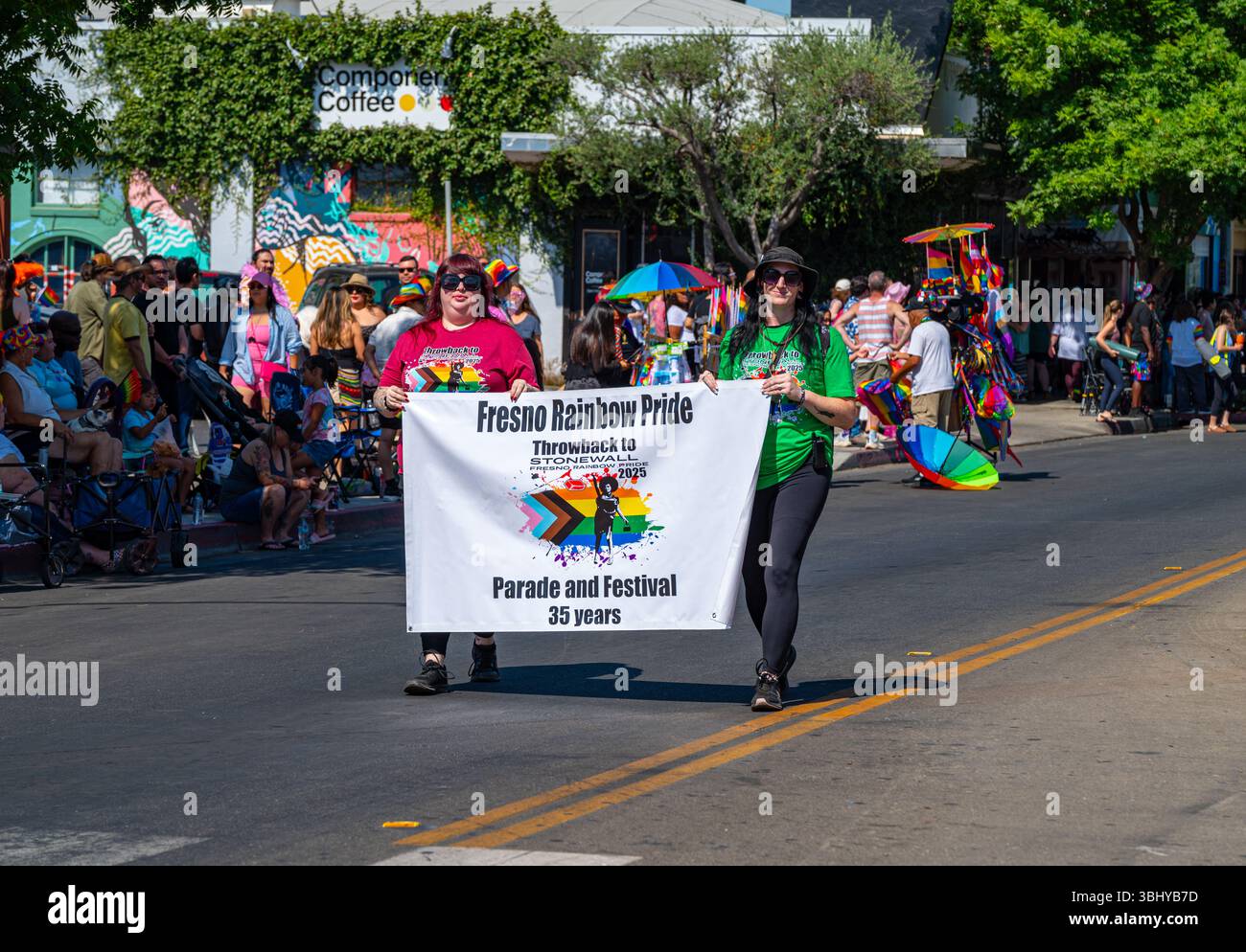 Two people carry the official banner at the beginning of Fresno’s annual Rainbow Pride parade event on E. Olive St. The event celebrated its 35th year. Stock Photo