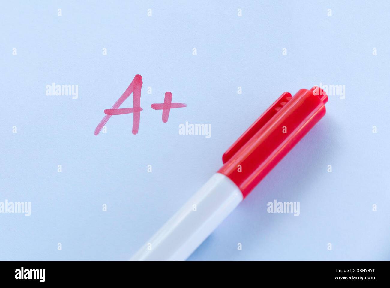 A+ Grade on Exam Paper with Red Pen on White Background Stock Photo - Alamy