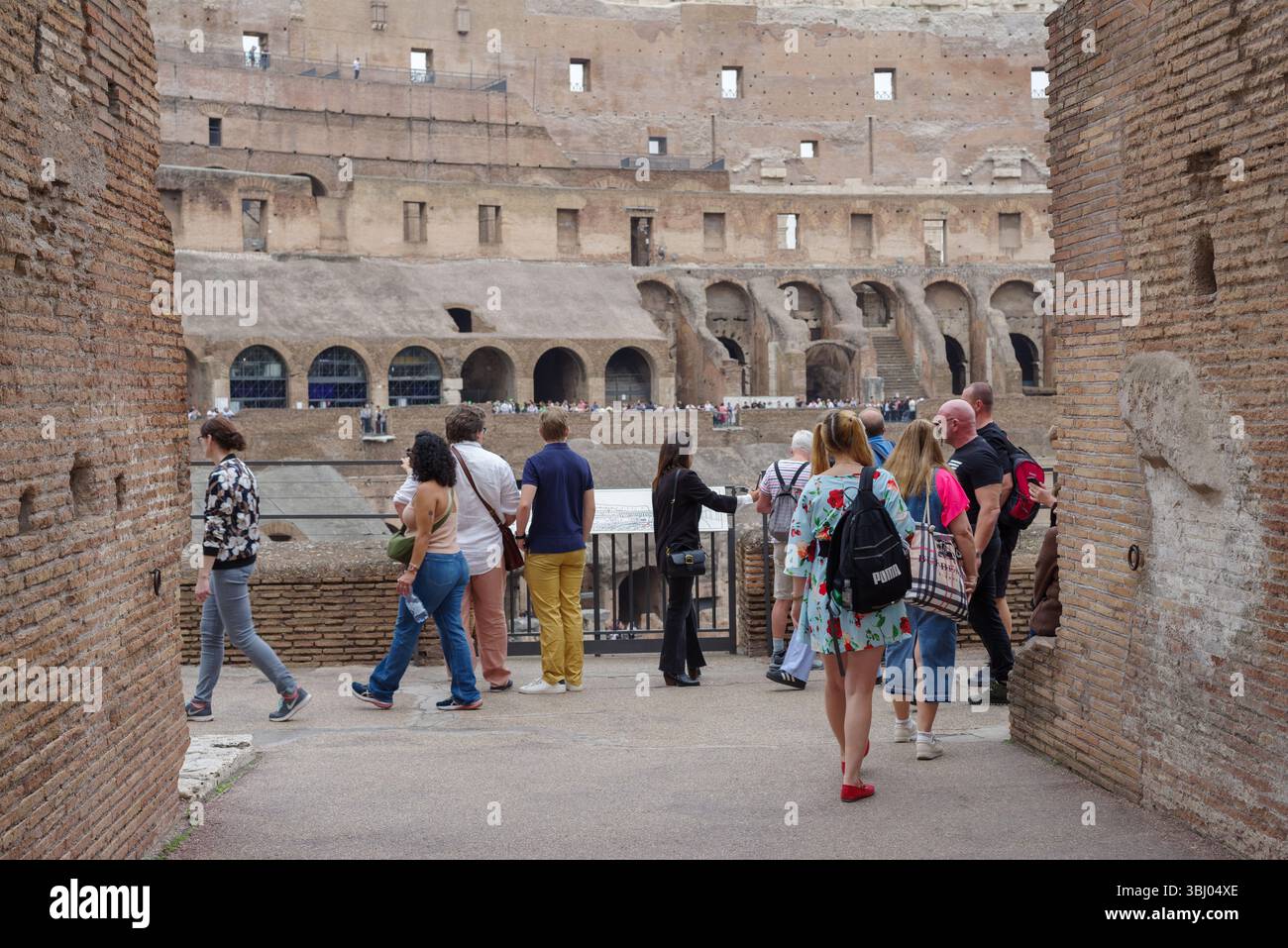 Inside of the Roman Colosseum amphitheatre with tourists visiting the ...