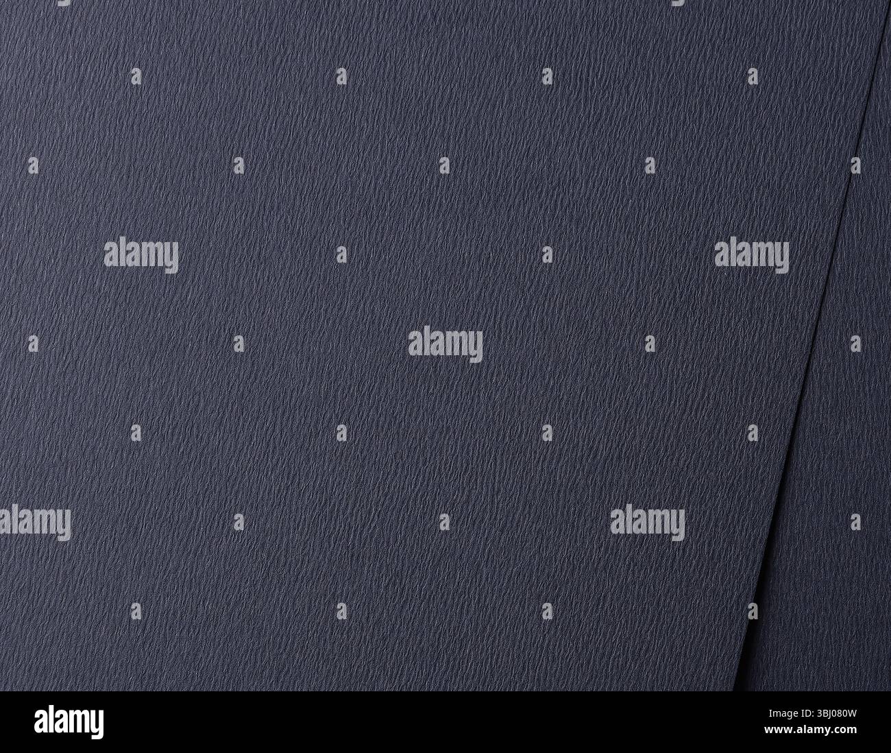 Dark blue matte paper texture with a smooth, striated finish, featuring a subtle, abstract ripple pattern. Elegant and refined design, perfect for mod Stock Photo