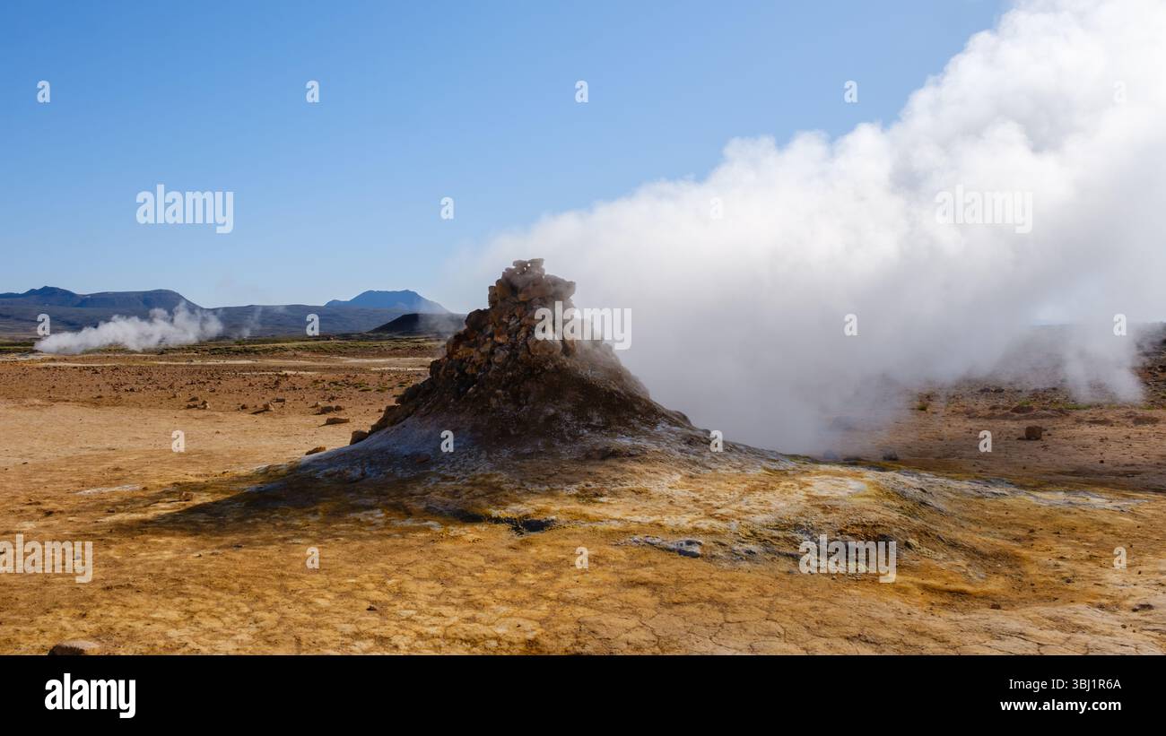 Hot steam erupts from rugged geothermal geysers in Hverir Iceland, showcasing the natural beauty of the terrain and the unique geological features. This stunning landscape is a testament to natures power. Stock Photo
