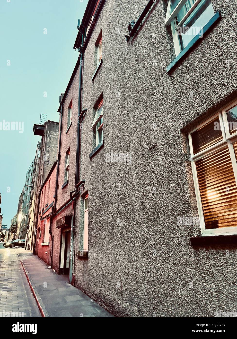 Twilight view of quiet street in Ropewalks, Liverpool, with tall pebbledash terraced buildings and soft dusk light - Smartphone Captured Stock Image