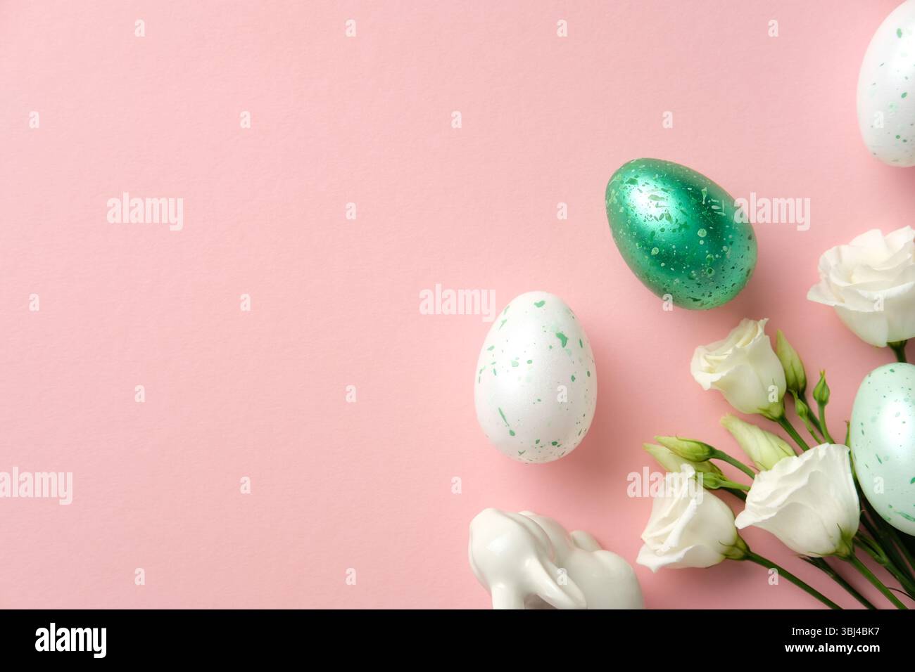 Happy Easter concept. Flat lay composition with speckled eggs, delicate white flowers, and a ceramic on pastel pink background Stock Photo