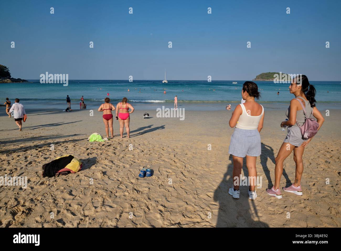 On an early morning, young female tourists visit Kata Yai Beach in Phuket, Thailand Stock Photo