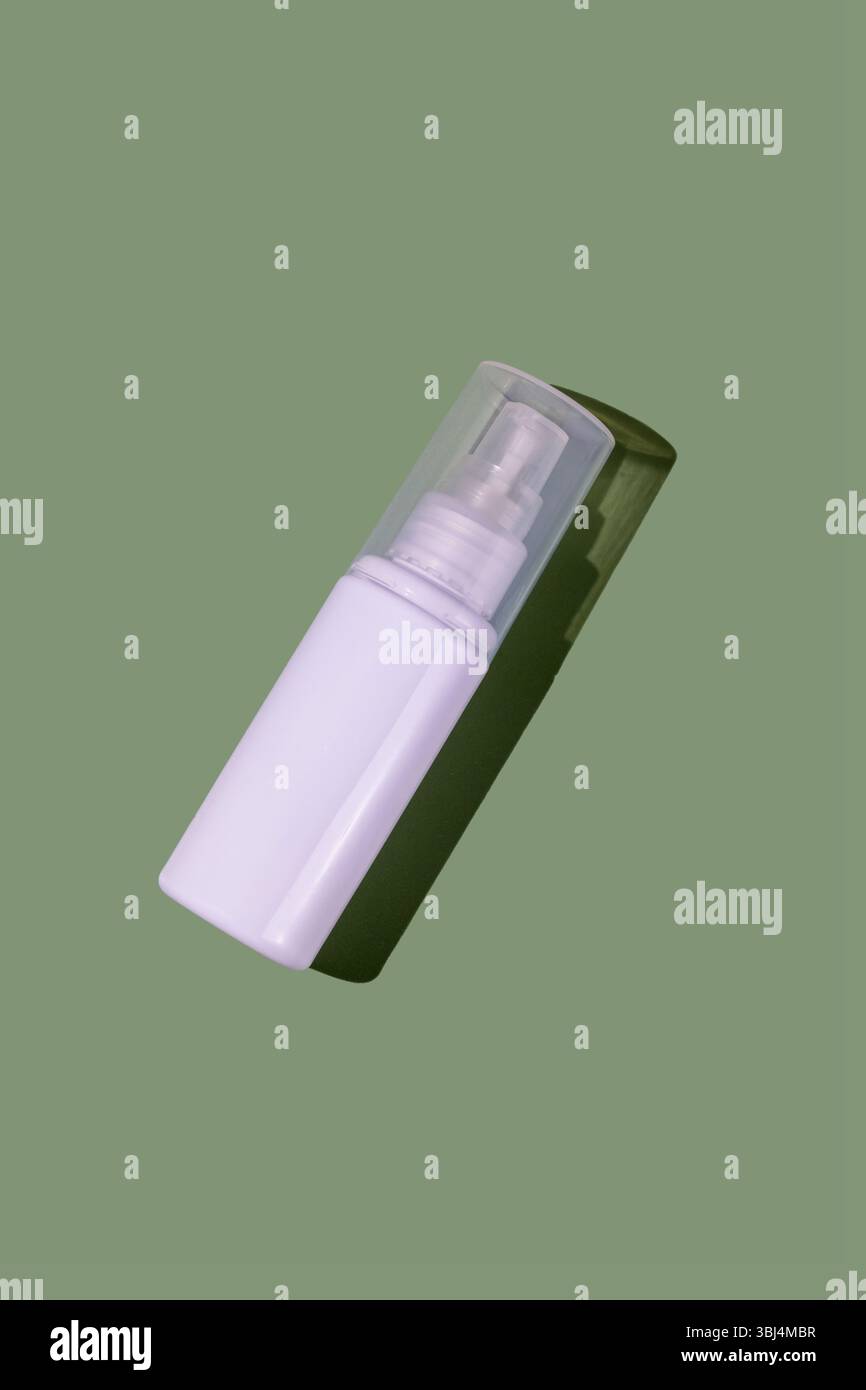 White transparent cosmetics plastic bottle, green background Stock Photo