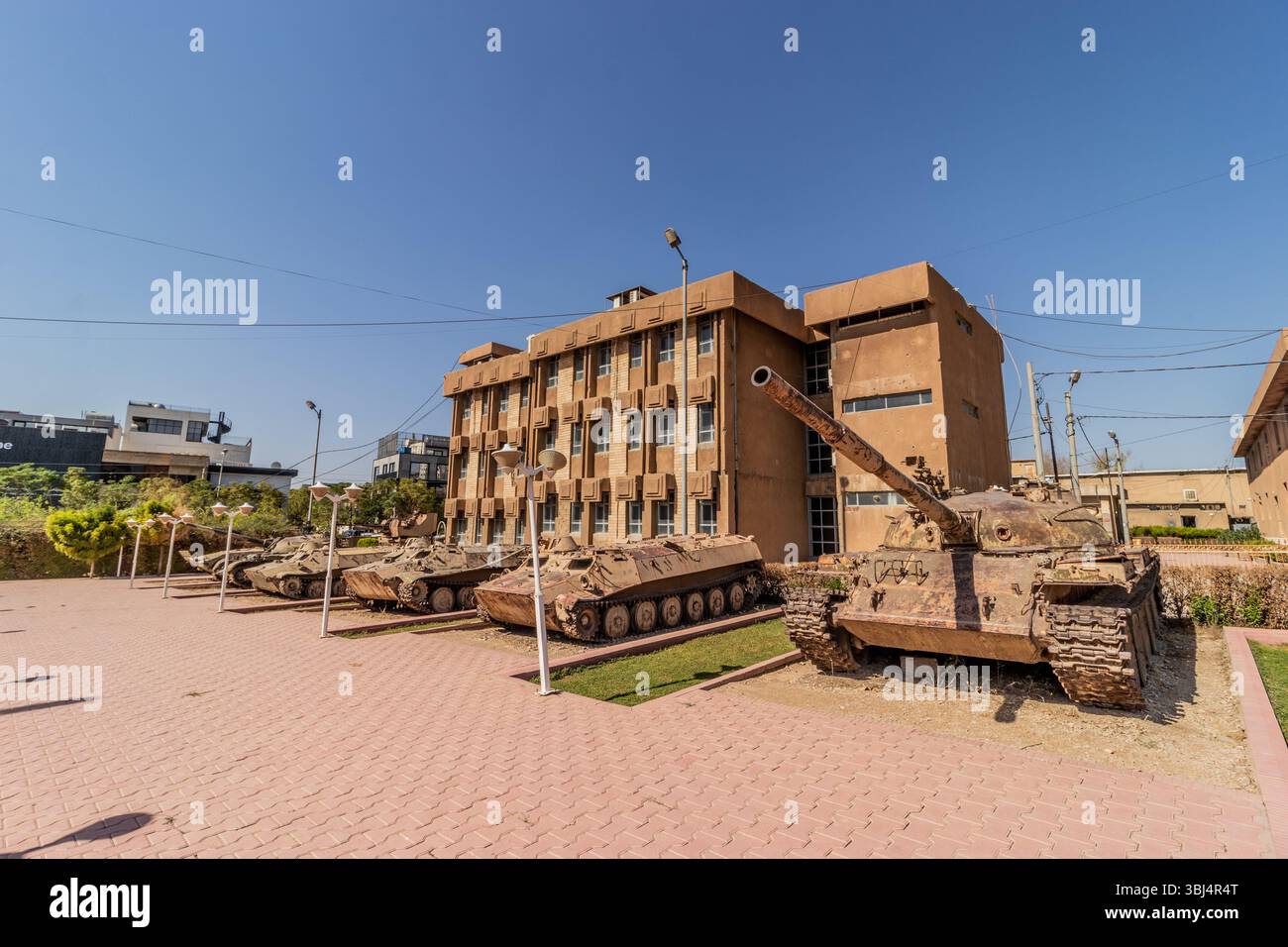 SULAYMANIYAH, IRAQ - OCTOBER 6, 2022: Tanks and armored vehicles at the grounds of Amna Suraka (Red prison) museum in Sulaymaniyah (Slemani), Kurdista Stock Photo