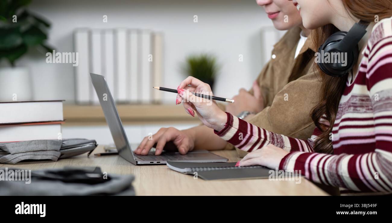 Focused Learning Environment. Students collaborating on laptops while studying. Stock Photo
