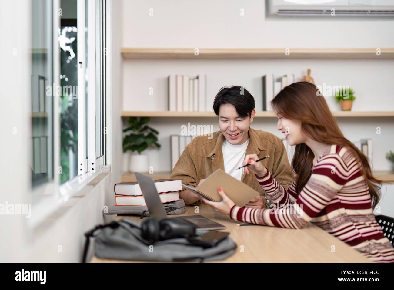 Collaborative Learning Environment. Two students discussing project ideas in modern workspace. Stock Photo