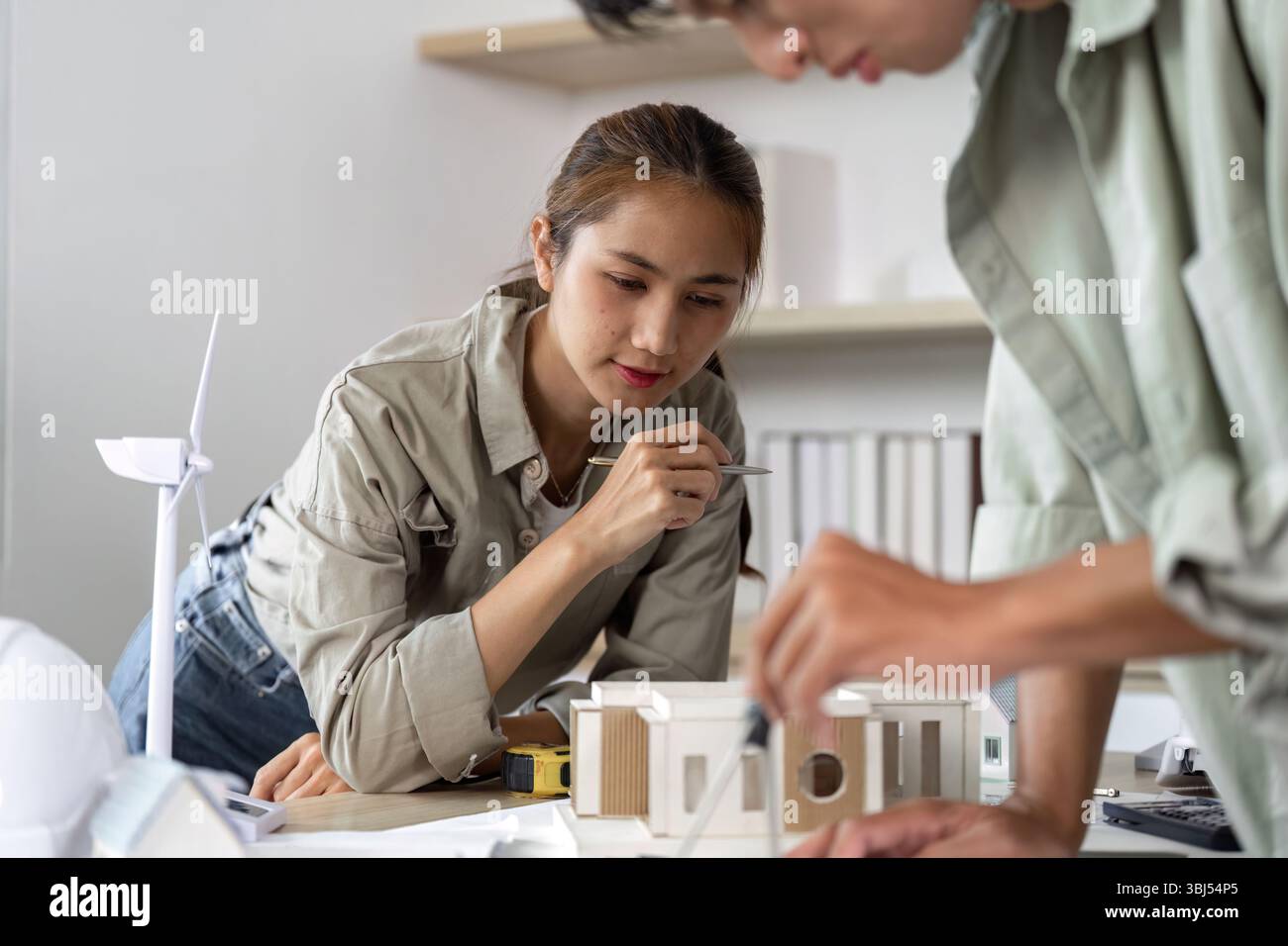 Architects Collaborating on Sustainable Design Project with Model Stock Photo