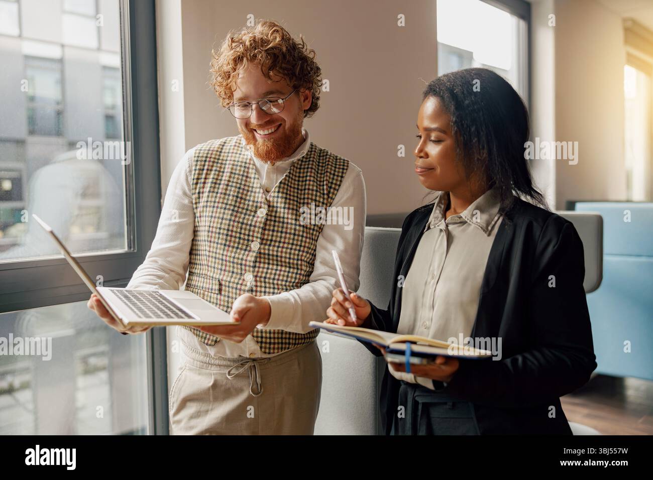 Collaborative professionals analyze data on laptops in a modern, innovative office Stock Photo