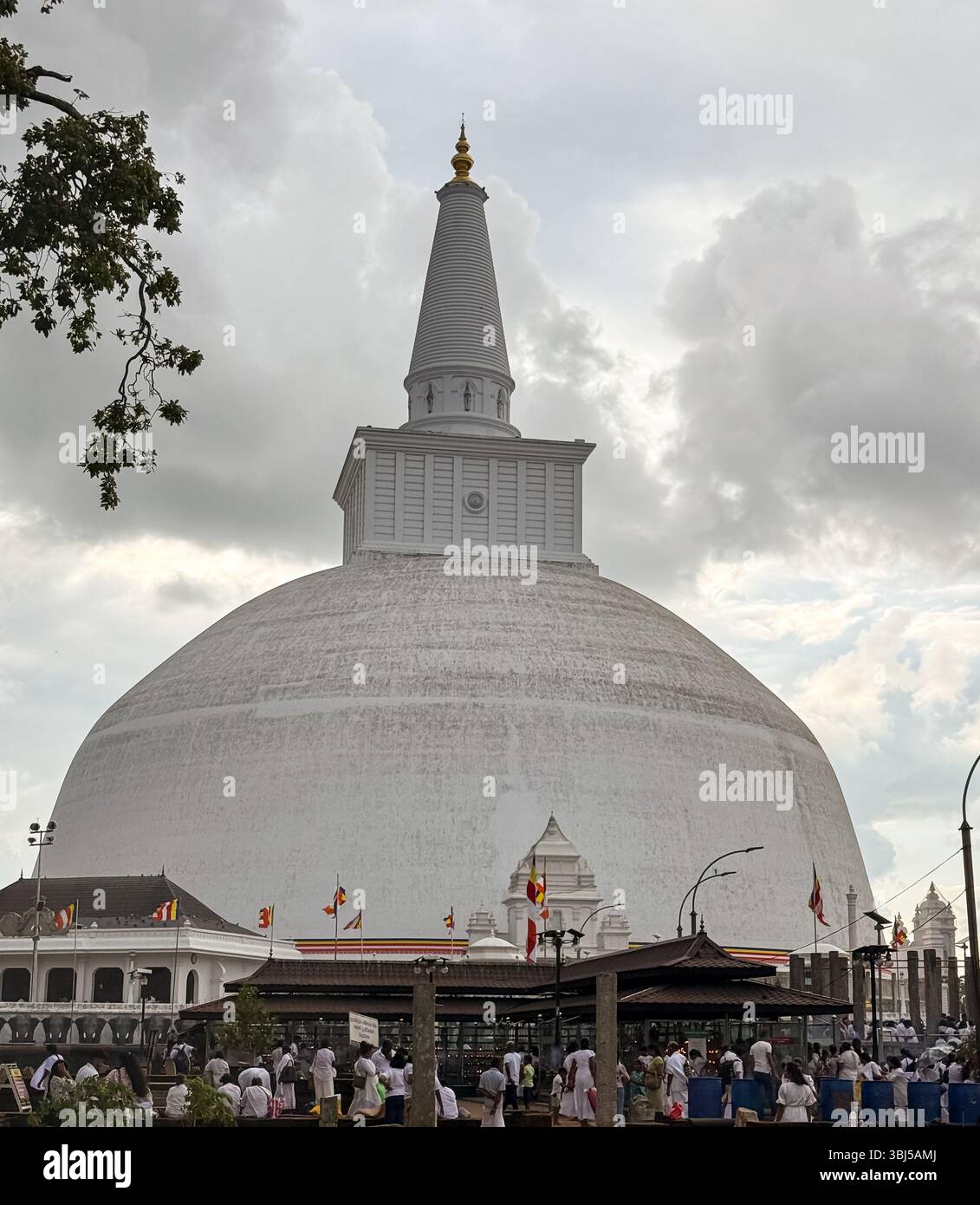Pilgrims and visitors gathered around the Ruwanwelisaya stupa in Anuradhapura, Sri Lanka, during the late afternoon - Smartphone Captured Stock Image