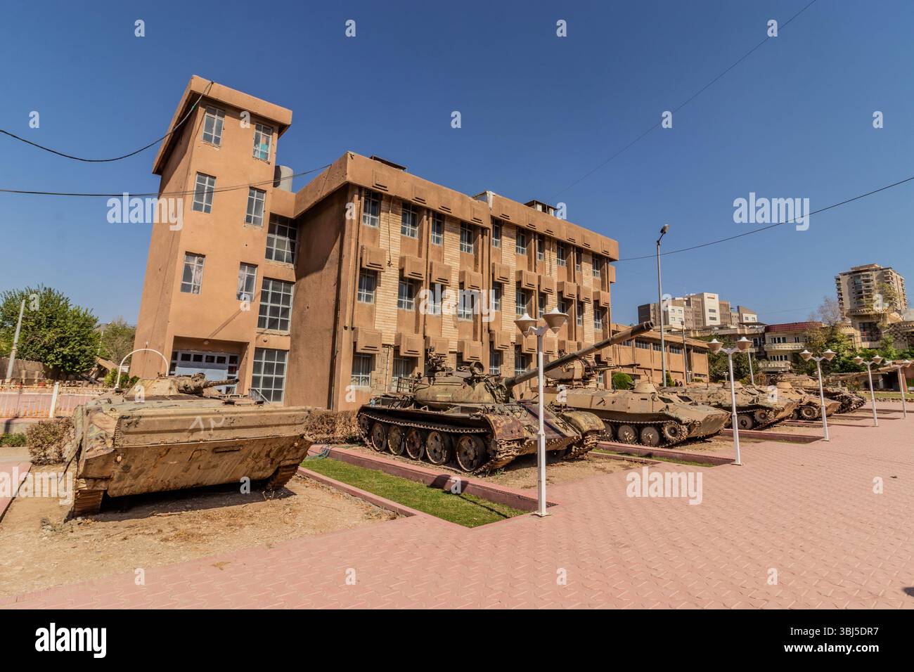 SULAYMANIYAH, IRAQ - OCTOBER 6, 2022: Tanks and armored vehicles at the grounds of Amna Suraka (Red prison) museum in Sulaymaniyah (Slemani), Kurdista Stock Photo