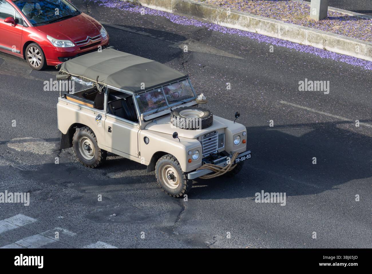 Beige land rover series iii driving on an asphalt road, seen from above ...