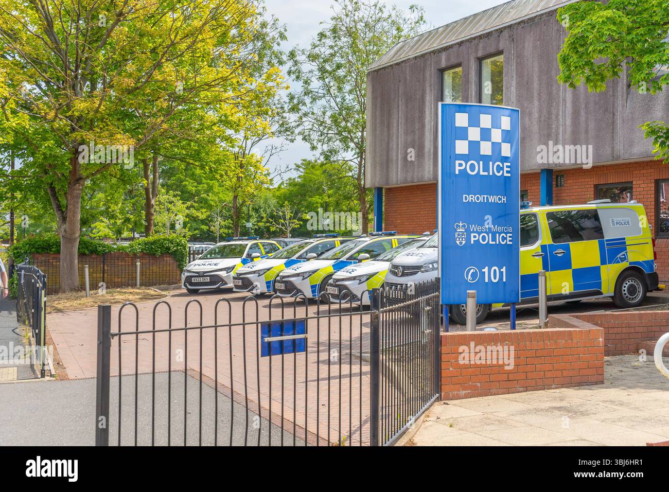 Exterior view of Droitwich Police Station, Worcestershire, UK, with five police vehicles parked in front of the building. Stock Photo
