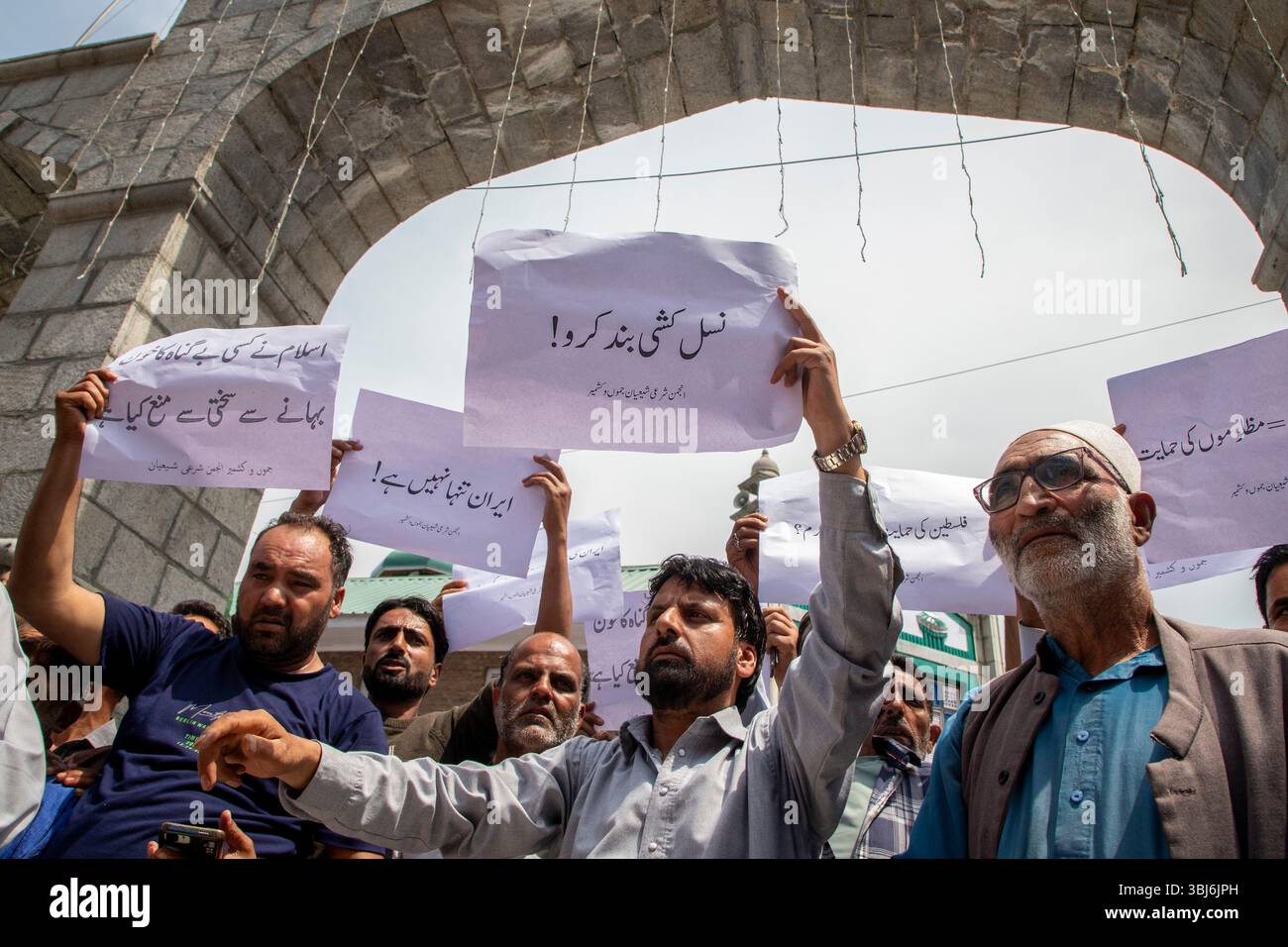 Budgam, India. 13th June, 2025. Kashmiri Shiite Muslims hold placards ...