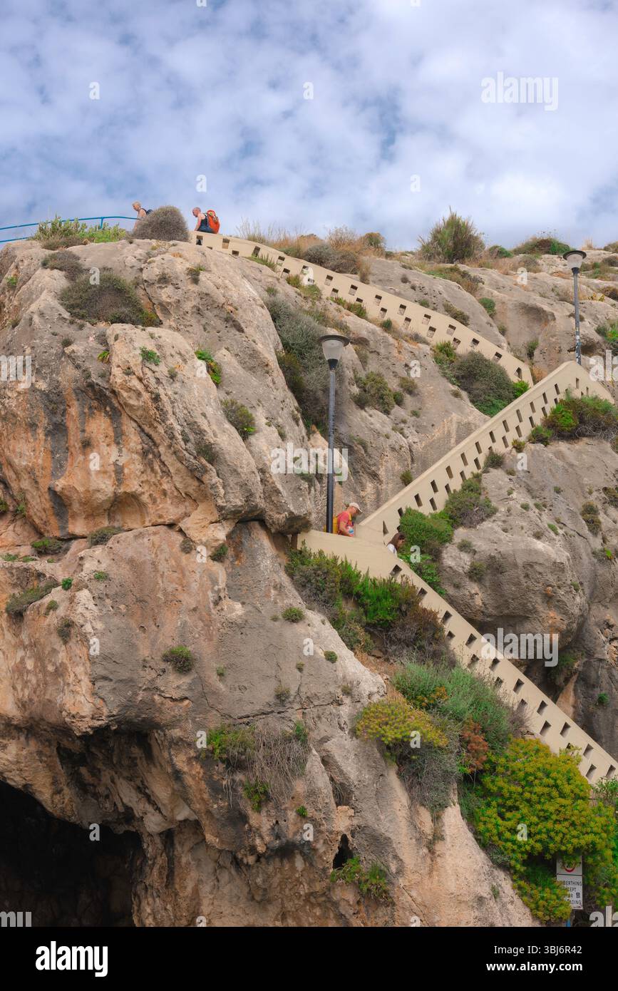 Xlendi cliff staircase, view of the stairs leading to the popular cliff-top walkway sited on cliffs above the northern side of Xlendi Bay, Gozo, Malta Stock Photo