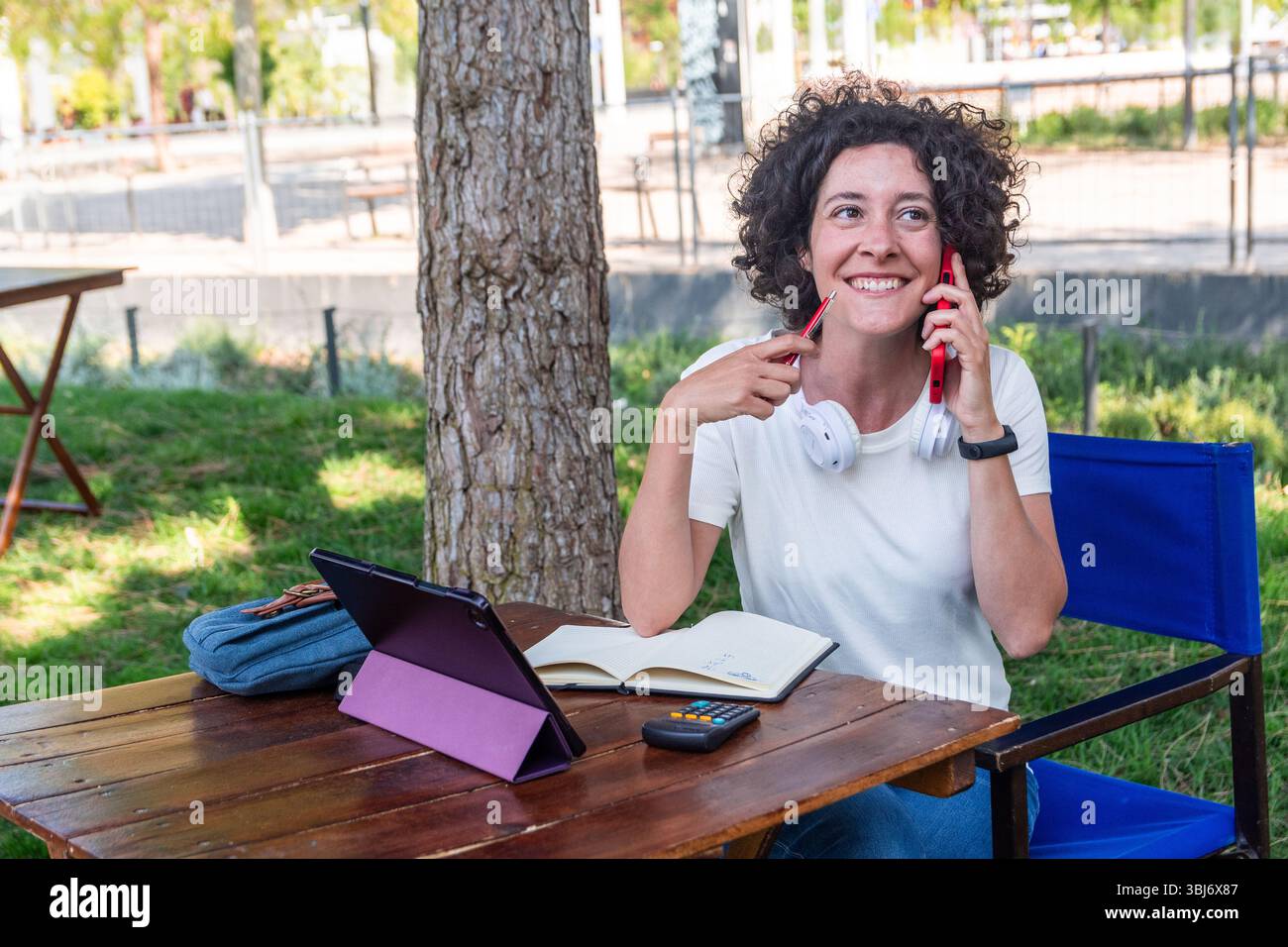 Digital nomad working outdoors and talking on phone Stock Photo