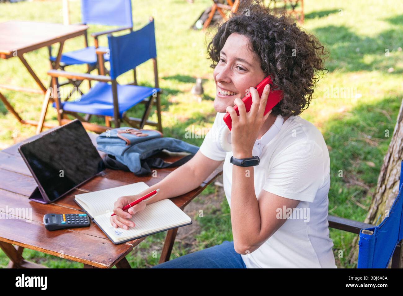 Digital nomad working remotely outdoors and talking on phone Stock Photo