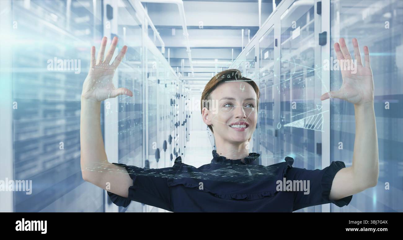 Engineer in ruffled top using holographic display in data center aisle, with server racks Stock Photo