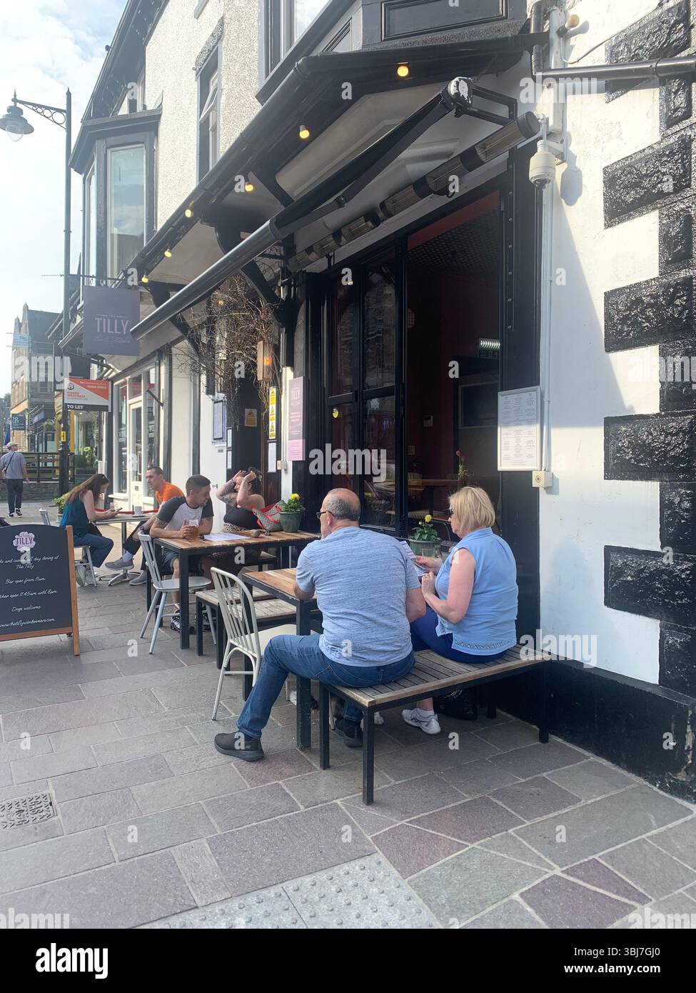 Lake Windermere shop shops town visit old historic history water pond outside people sit sat house houses pub beer eat food dinning rent hotel tourist - Smartphone Captured Stock Image