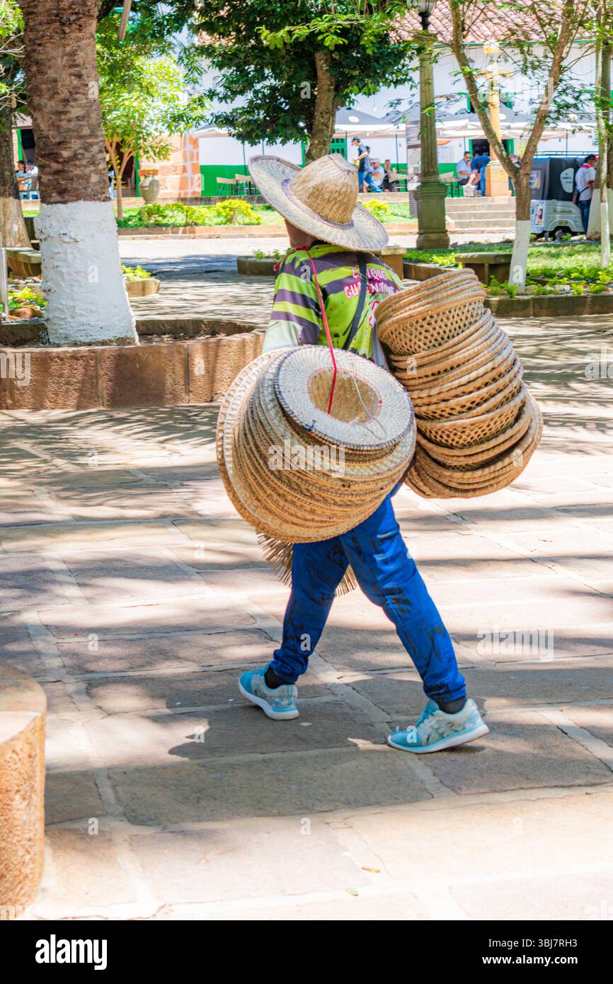 Barichara, Santander, Colombia, October 11, 2024. Vertical image of a street vendor selling handcrafted wicker hats in Barichara’s central park. The v Stock Photo