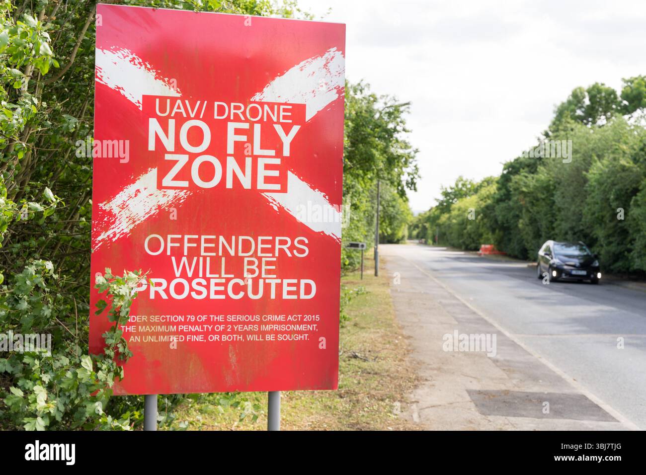 No Drone Zone Ahead: Bold Red Roadside Sign Warns UAVs to Stay Clear – White Text Alerts Pilots of Restricted Airspace England UK Stock Photo