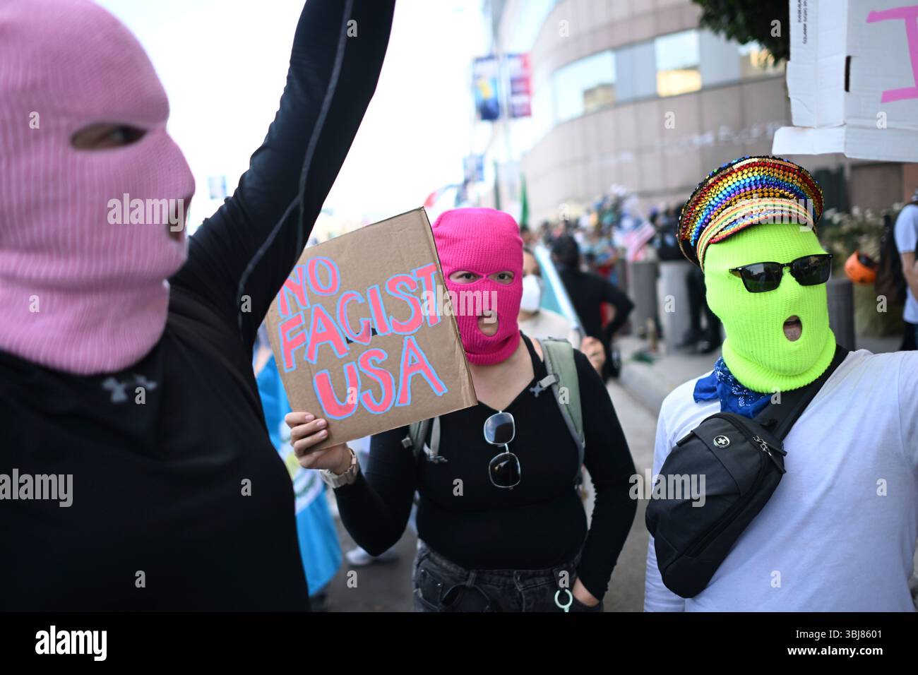 Demonstrators wearing masks hold signs outside the Federal Building ...