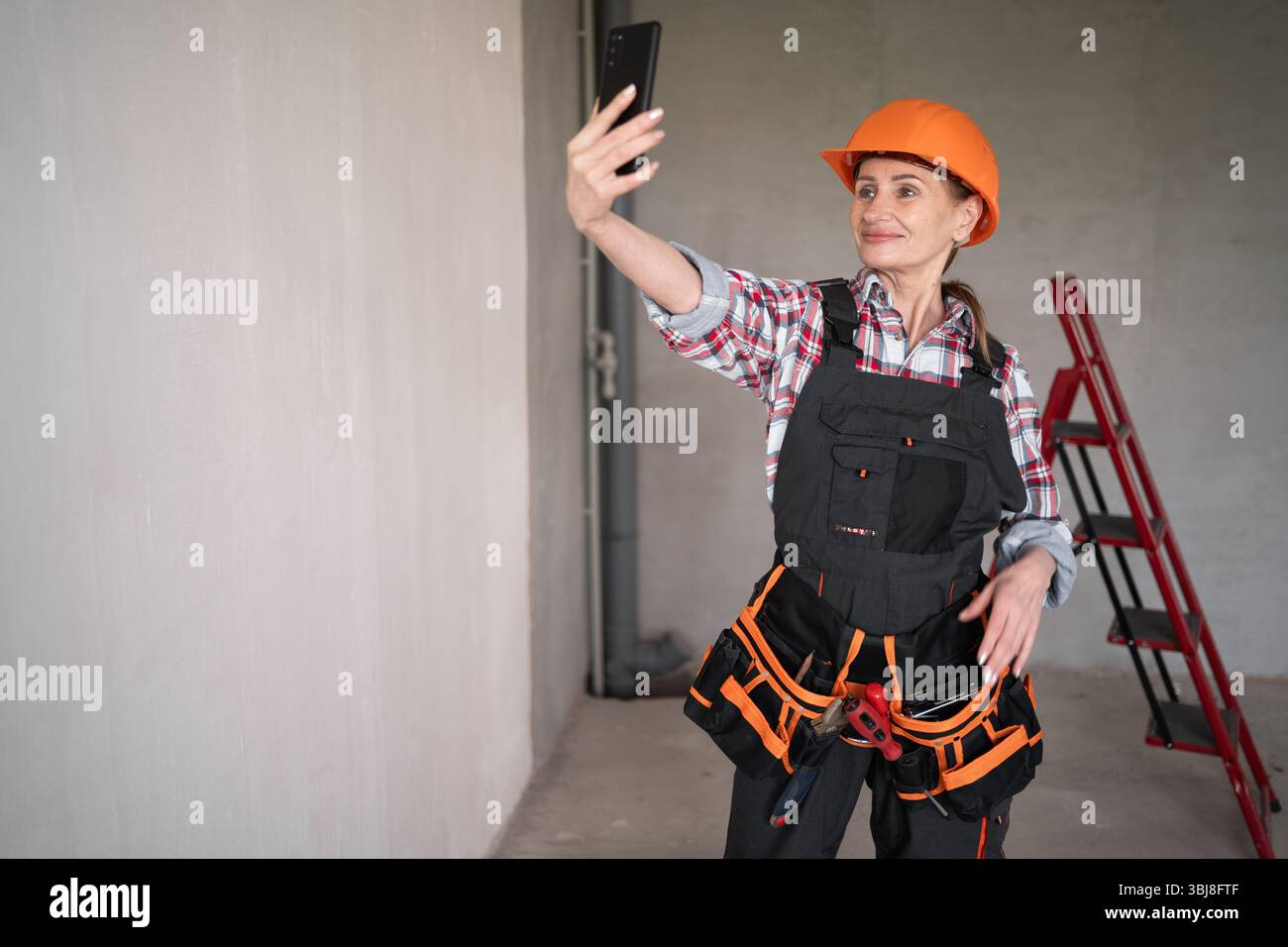 Female builder or architect having video call at construction site Stock Photo