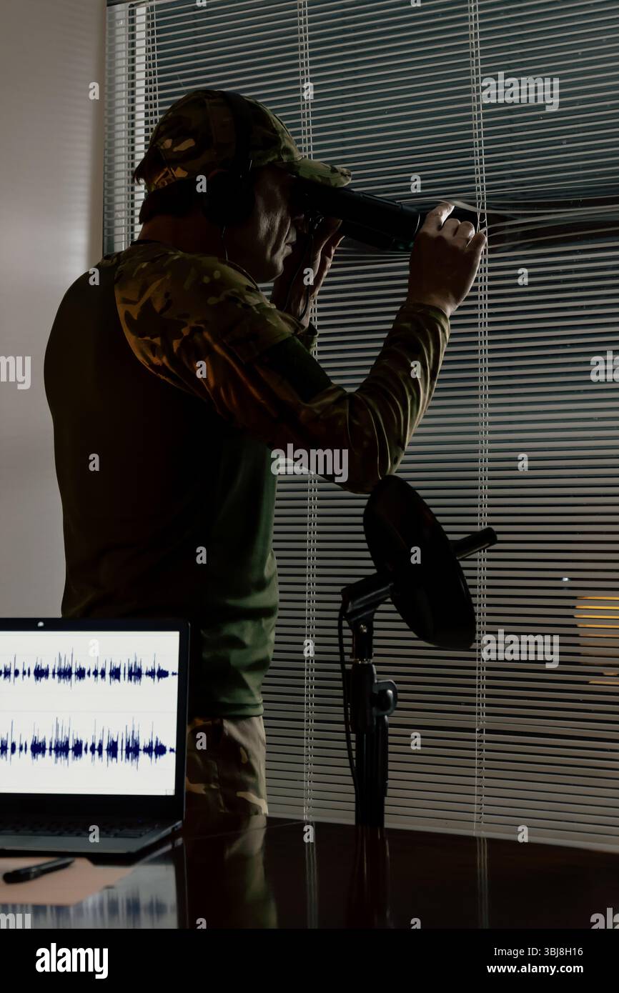 Intelligence officer conducting surveillance from a closed room ...