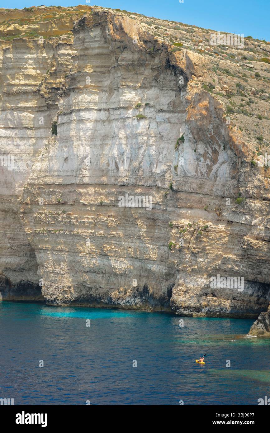 Malta cliff Gozo, view across Xlendi Bay towards the sheer cliffs lining the south coast of the island of Gozo, Malta Stock Photo