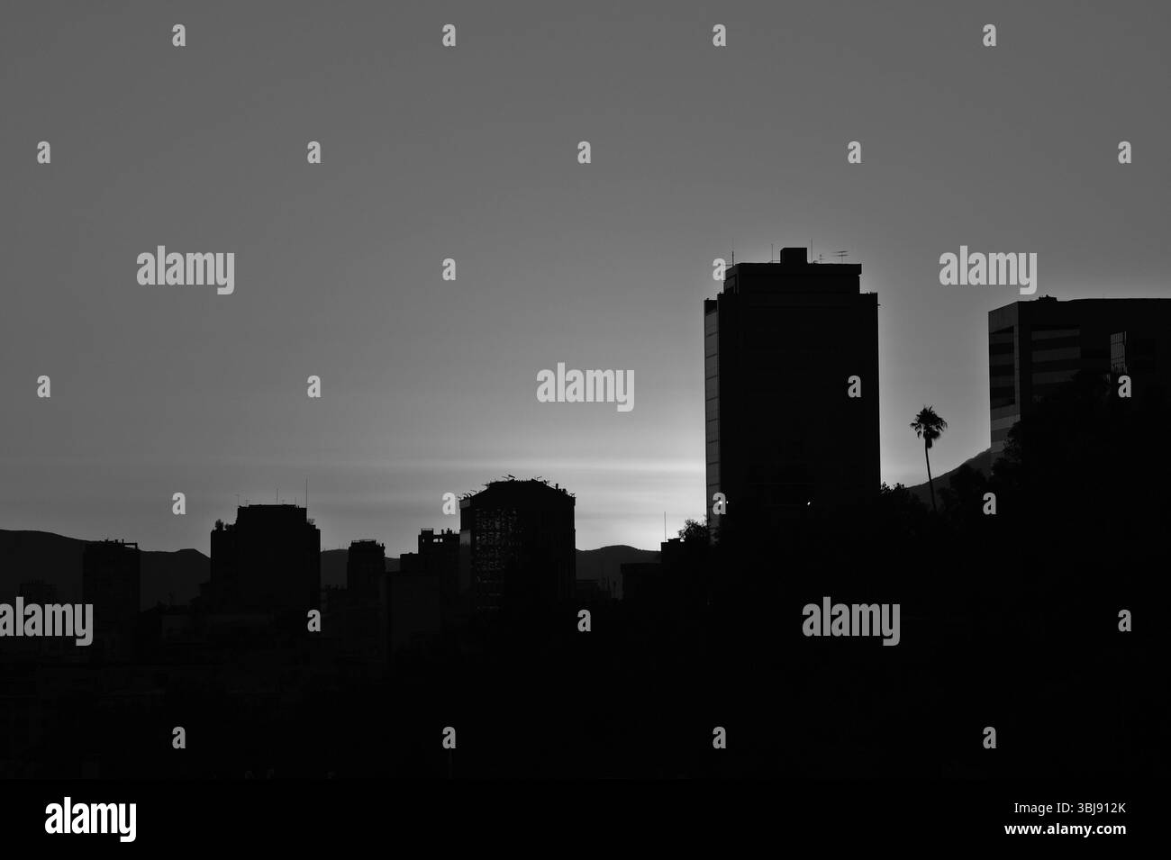 Silhouetted city buildings against a twilight sky. Stock Photo