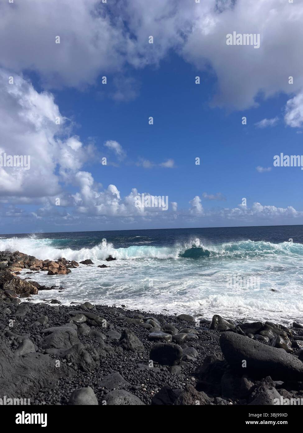 The beautiful and magical black sand beaches on the Big Island of Hawai'i, USA with volcanic black lava rock and crashing waves. - Smartphone Captured Stock Image