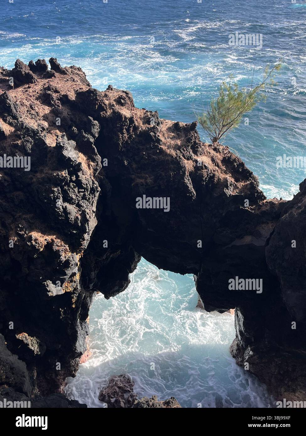 The beautiful and magical black sand beaches on the Big Island of Hawai'i, USA with volcanic black lava rock and crashing waves. - Smartphone Captured Stock Image