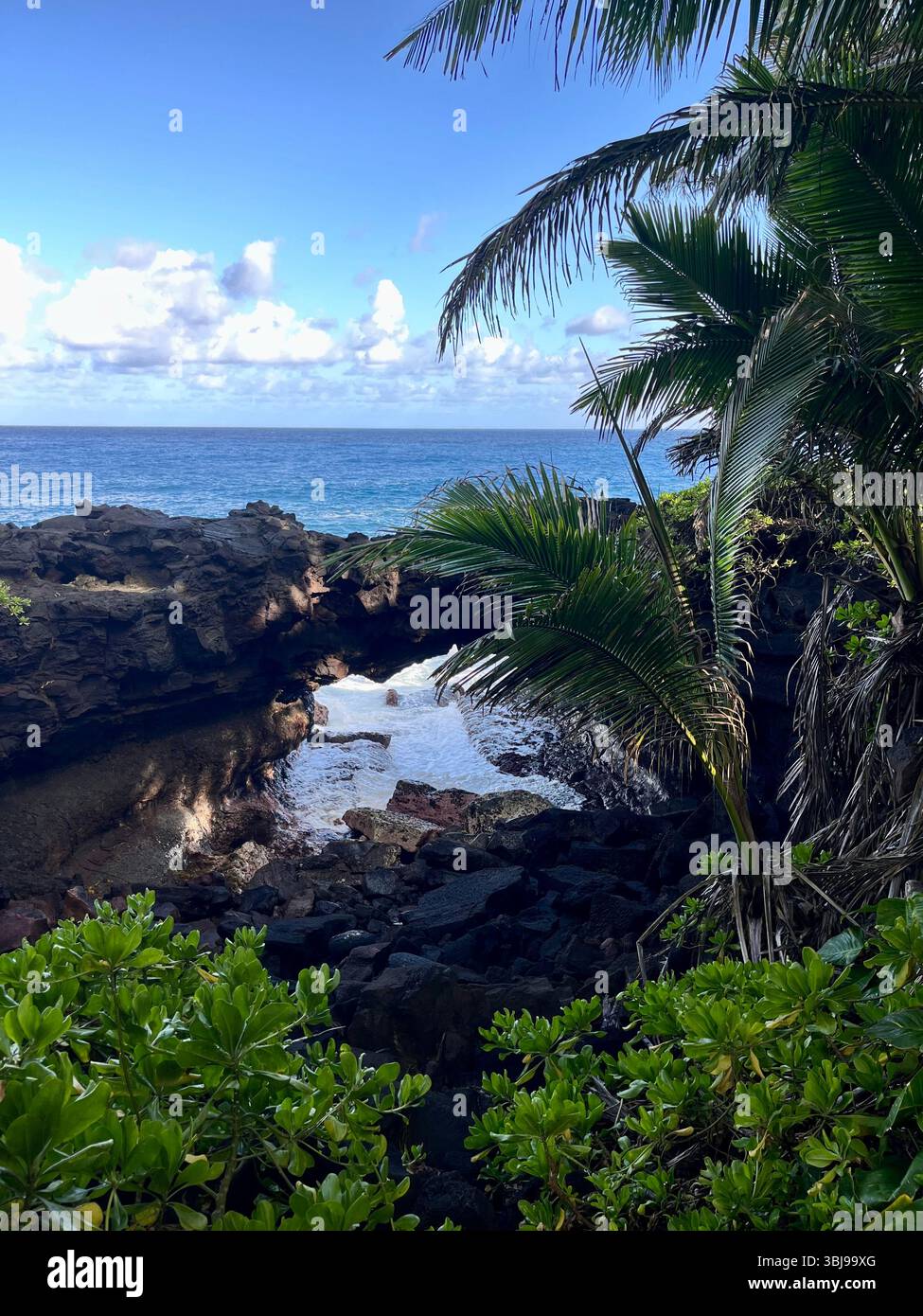 The beautiful and magical black sand beaches on the Big Island of Hawai'i, USA with volcanic black lava rock and crashing waves. - Smartphone Captured Stock Image