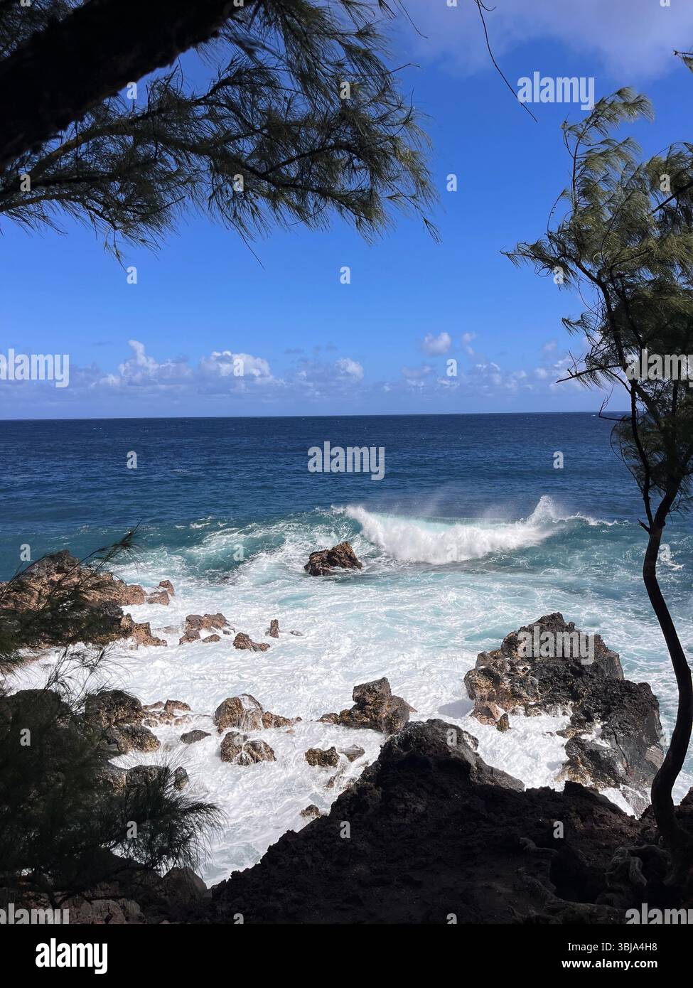 The beautiful and magical black sand beaches on the Big Island of Hawai'i, USA with volcanic black lava rock and crashing waves. - Smartphone Captured Stock Image