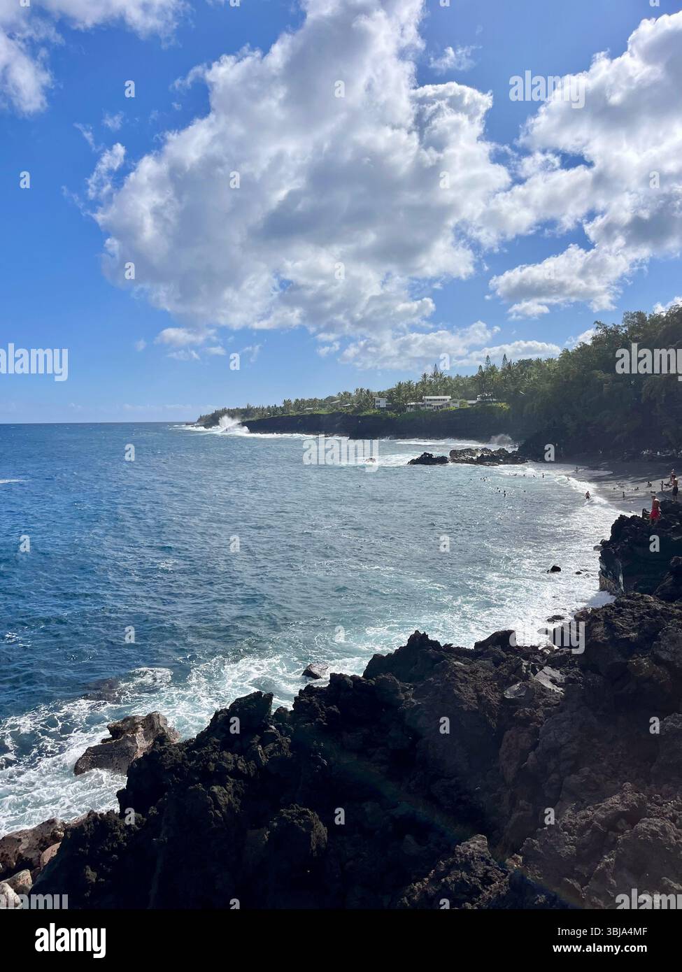 The beautiful and magical black sand beaches on the Big Island of Hawai'i, USA with volcanic black lava rock and crashing waves. - Smartphone Captured Stock Image