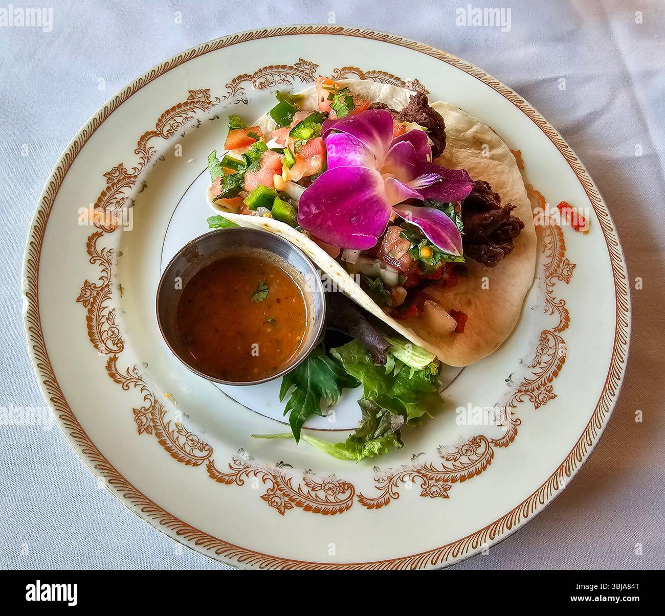 breaded and deep fried beef tenderloin strips on a soft flour tortilla with pico de gallo and salsa served on an old china plate - Smartphone Captured Stock Image
