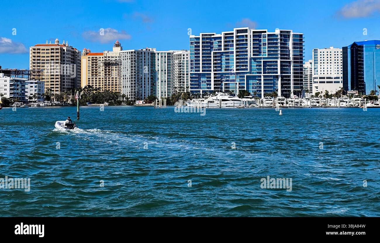 A man takes an inflatable dinghy to the marina in the harbor in Sarasota, Florida - Smartphone Captured Stock Image