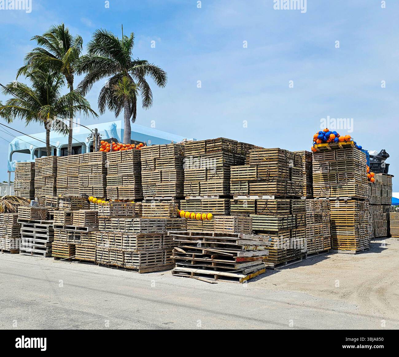 Crab pots and floats at a depot in Florida.  Wooden crab pots are stacked on pallets, along with colorful floats. - Smartphone Captured Stock Image